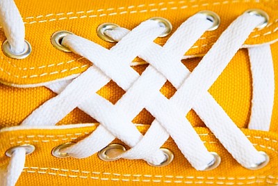 Białe sznurówki na żółtych trampkach