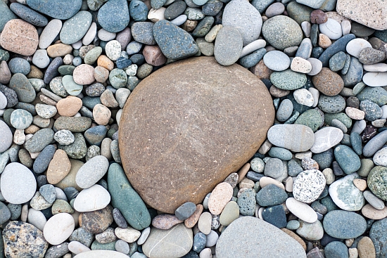 pebbles on the beach with one big pebble