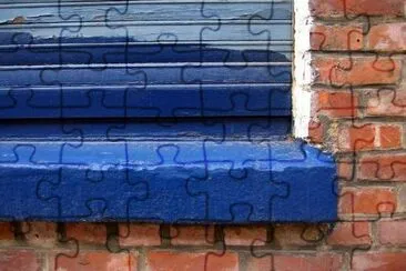 Pared de ladrillo y una ventana azul