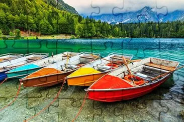 båtar på den kristallklara alpina sjön, Lake Fusine