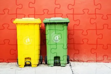 Duże zielone i żółte pojemniki na kółkach do recyklingu