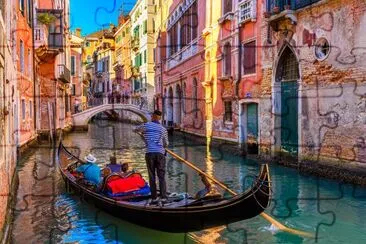 Schmaler Kanal mit Gondel und Brücke in Venedig