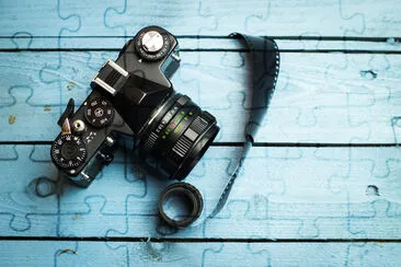 Old film camera, and old film on a blue wooden bac jigsaw puzzle