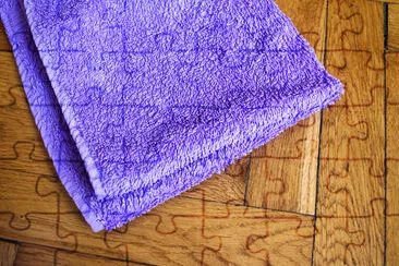 Serviette pliée colorée sur fond de bois: violet c