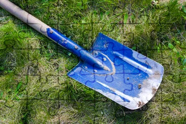 Blaue Schaufel auf einem grünen Gras