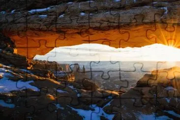 The sun peeks through Mesa Arch in Canyonlands Nat