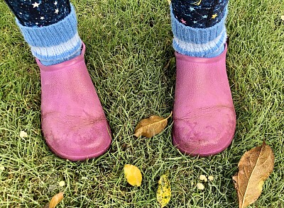 Pink boots in autumn garden