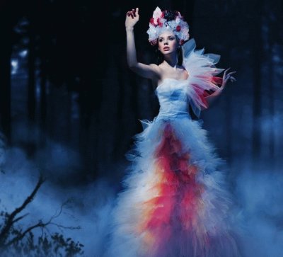 Mujer en le bosque con vestido blanco y rojo