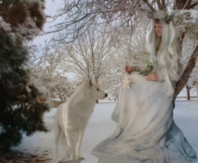 Lobo con mujer vestida de blanco en invierno