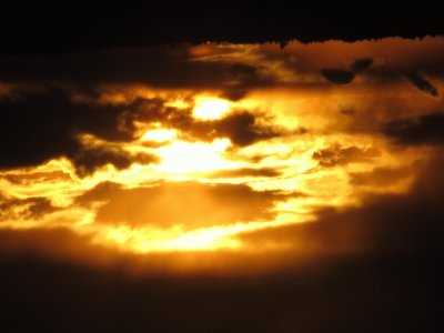 Setting sun peeking through dark clouds